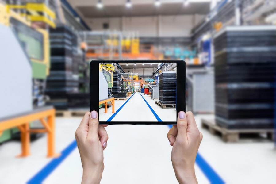 Person holding tablet on manufacturing floor