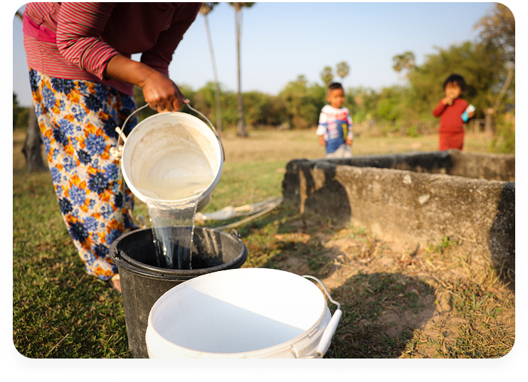 Sun Seiya, 33, carries buckets to collect water with her daughter Sreyleak, 4, in Sameakki Mean Chey District, Kampong Tralach District, Rolea B’ier district, Kampong Chhnang Province, Cambodia, Feb 2023.
